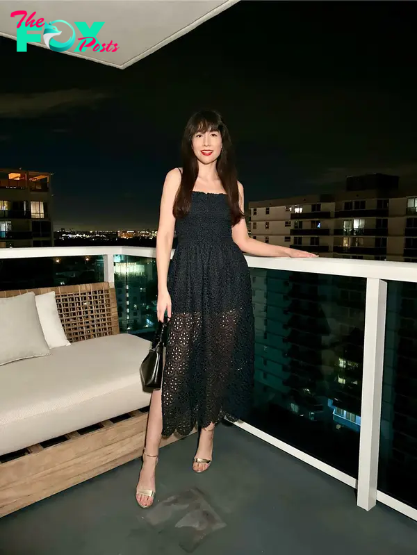 The author wearing a black dress on a hotel balcony