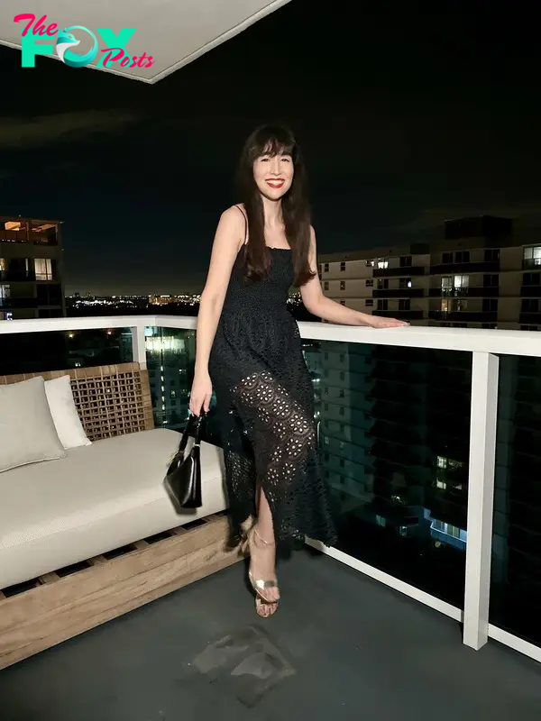 The author wearing a black dress on a hotel balcony