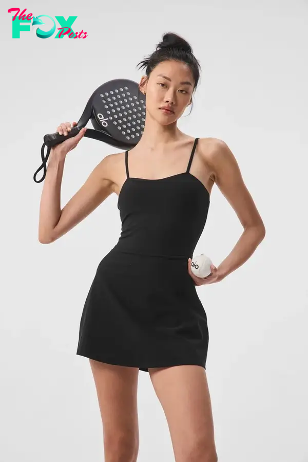A model in a black exercise dress