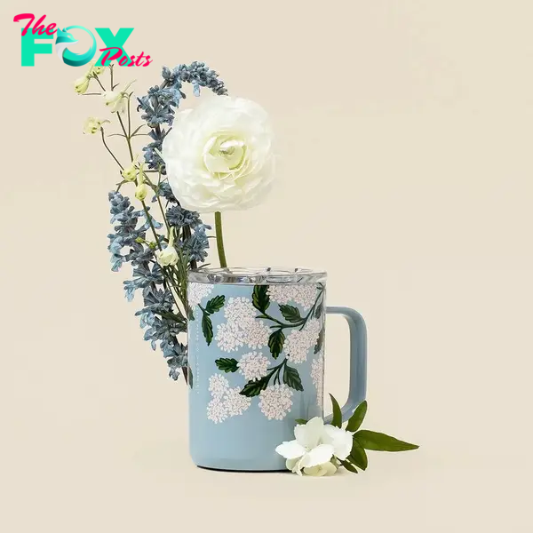 A coffee mug surrounded by flowers