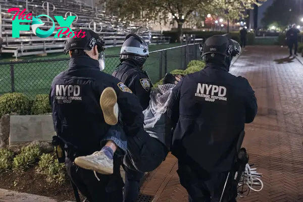 Police carry an arrested protestor at Columbia University.