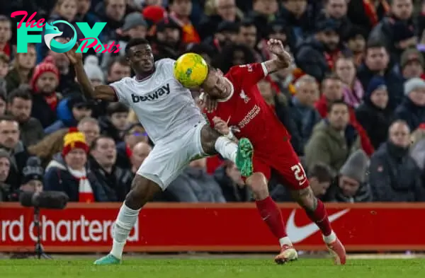 LIVERPOOL, ENGLAND - Wednesday, December 20, 2023: Liverpool's Kostas Tsimikas (R) is challenged by West Ham United's Mohammed Kudus during the Football League Cup Quarter-Final match between Liverpool FC and West Ham United FC at Anfield. (Photo by David Rawcliffe/Propaganda)