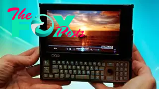 Fingers holding up a handheld PC with a slide out keyboard.