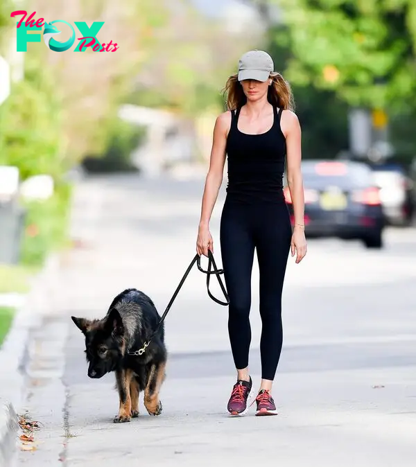 Gisele Bundchen walks her dog Alfie wearing an all-black outfit.