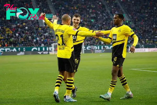 Dortmund's Dutch forward #21 Donyell Malen (R) celebrates with Dortmund's Belgian defender #24 Thomas Meunier and Dortmund's English forward #43 Jamie Bynoe-Gittens after scoring the equalizing 1-1 goal during the German first division Bundesliga football match between FC Augsburg 1907 and BVB Borussia Dortmund in Augsburg, southern Germany, on December 16, 2023. (Photo by MICHAELA REHLE / AFP) / DFL REGULATIONS PROHIBIT ANY USE OF PHOTOGRAPHS AS IMAGE SEQUENCES AND/OR QUASI-VIDEO