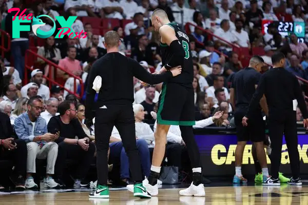 MIAMI, FLORIDA - APRIL 29: Kristaps Porzingis #8 of the Boston Celtics leaves the game against the Miami Heat during the second quarter after suffering an apparent injury in game four of the Eastern Conference First Round Playoffs at Kaseya Center on April 29, 2024 in Miami, Florida. NOTE TO USER: User expressly acknowledges and agrees that, by downloading and or using this photograph, User is consenting to the terms and conditions of the Getty Images License Agreement.   Megan Briggs/Getty Images/AFP (Photo by Megan Briggs / GETTY IMAGES NORTH AMERICA / Getty Images via AFP)