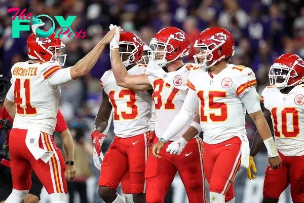 James Winchester and Travis Kelce giving each other a high five.