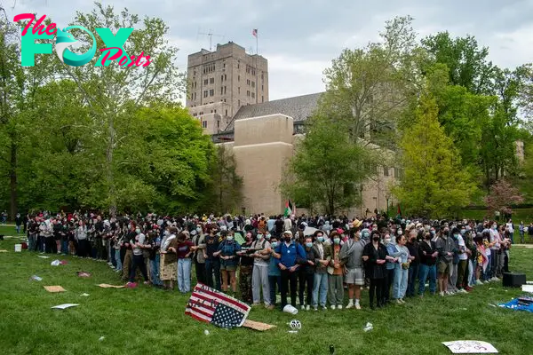 More than 100 pro-Palestinian protesters link arms to surround an encampment on April 26, outside the Indiana Memorial Union in Bloomington. Inside the encampment, there was food, medical supplies, tents, and a pile of backpacks.