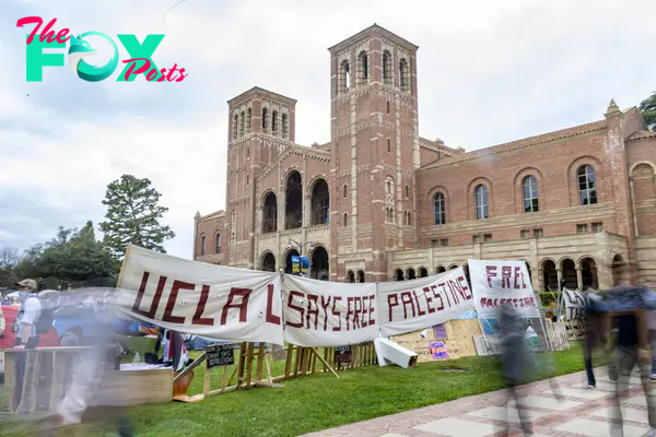 A poster reading “UCLA Says Free Palestine” hangs on the barrier of the pro-Palestinian encampment on April 25. The community expressed mixed sentiments toward the encampment, with some offering support and others voicing concerns.