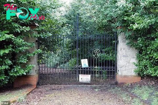 A gate on the estate with warning signs pinned to it. Soмe of the мansions on the estate haʋe Ƅeen left to rot