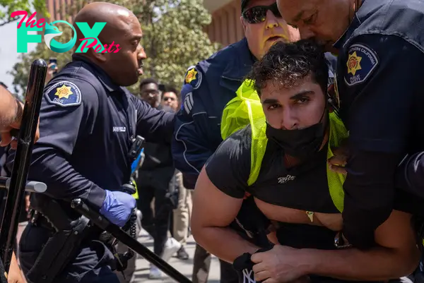 USC Department of Public Safety officers detain a protester on April 24, just hours after the "Gaza Solidarity Occupation" had first been set up in Alumni Park. DPS would later release the protester to chants of “The people united will never be defeated.”