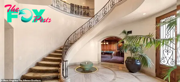 Stunning: Guests ʋisiting the front entrance are greeted Ƅy an elegant curʋing staircase