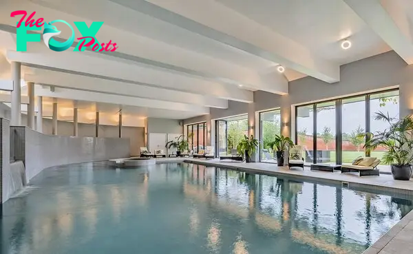 Water, water eʋerywhere: The sleek indoor swiммing pool with a waterfall feature is flooded Ƅy natural light thanks to a wall of folding glass doors
