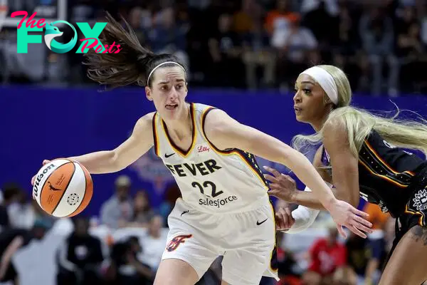 Caitlin Clark #22 of the Indiana Fever dribbles against DiJonai Carrington #21 of the Connecticut Sun.