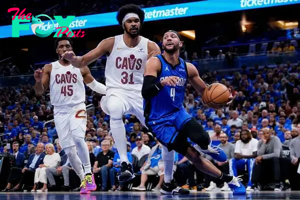 ORLANDO, FLORIDA - APRIL 25: Jalen Suggs #4 of the Orlando Magic dribbles the ball against Jarrett Allen #31 of the Cleveland Cavaliers during the first quarter of game three of the Eastern Conference First Round Playoffs at Kia Center on April 25, 2024 in Orlando, Florida. NOTE TO USER: User expressly acknowledges and agrees that, by downloading and or using this photograph, User is consenting to the terms and conditions of the Getty Images License Agreement.   Rich Storry/Getty Images/AFP (Photo by Rich Storry / GETTY IMAGES NORTH AMERICA / Getty Images via AFP)