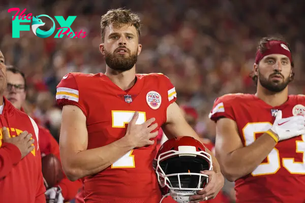 harrison butker in chiefs uniform with his hand on his heart