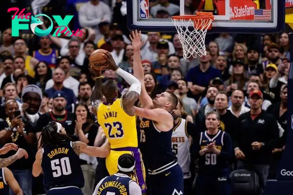 LeBron James (23) drives to the net against Denver Nuggets center Nikola Jokic (15).