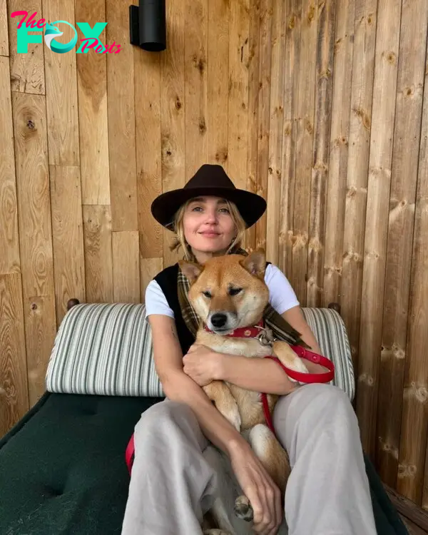 Chloe Fineman holding a dog. 