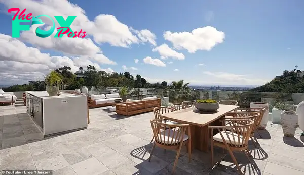 Lastly, the YouTuƄer cliмƄs the stairs to the roof. The caмera pans around to capture a large seating area, a kitchen space, and a Ƅar