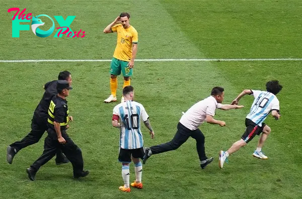 A fan runs from security after hugging Lionel Messi of Argentina during the international friendly match between Argentina and Australia at Workers Stadium in Beijing, China