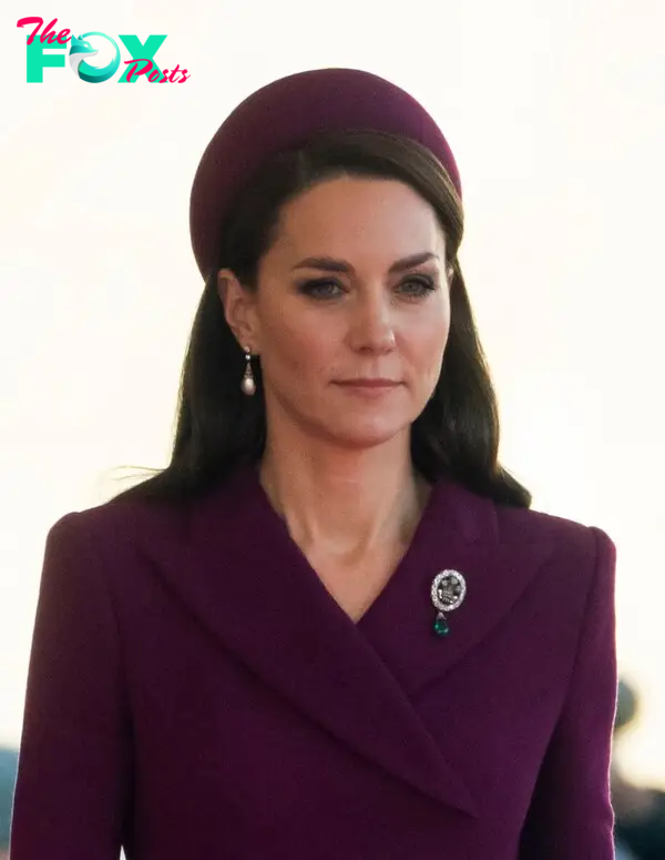 Princess Kate in a purple coat and pill-box hat with a diamond brooch.