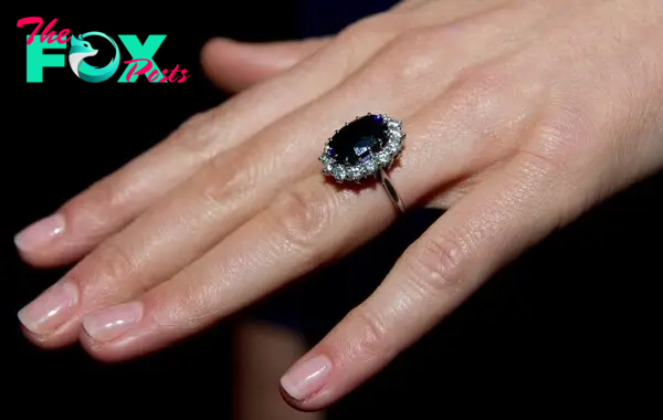 Kate Middleton's engagement ring, which was Princess Diana's before her on her hand. It is a 12-carat blue oval sapphire, surrounded by 14 solitaire diamonds, set on a white-gold band of 18 karats 