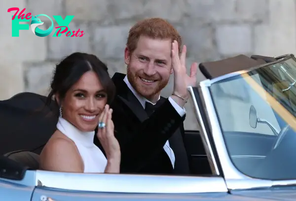 Prince Harry and Meghan Markle Wave from the seats of an open-top car. She is wearing a white halter top, he is wearing a black double-breasted tuxedo jacket, white shirt and black bow tie.