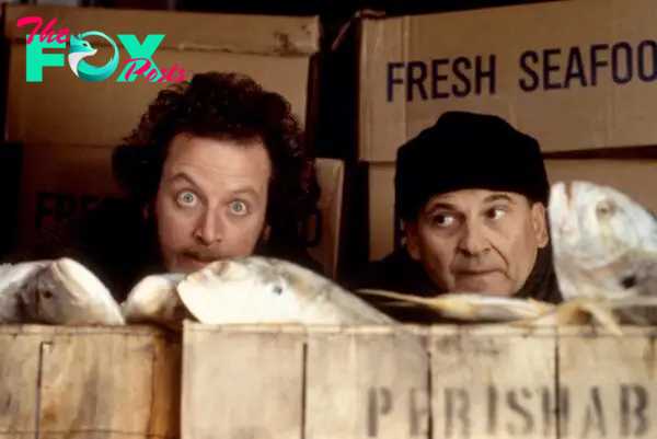 Joe Pesci and Daniel Stern in a scene "Home Alone 2: Lost in New York," hiding behind open boxes containing fresh fish