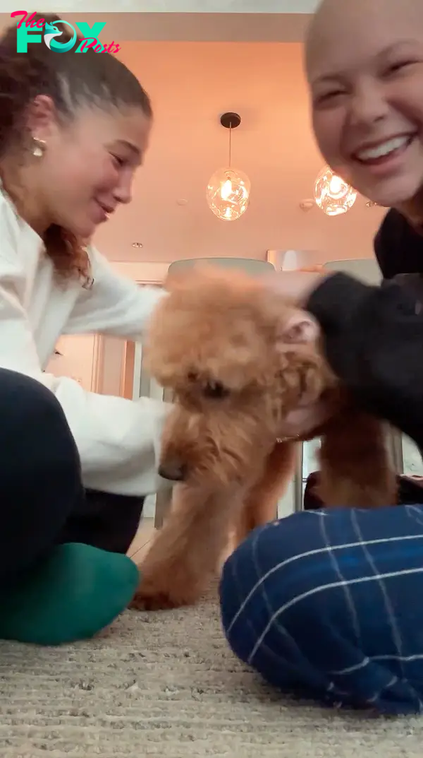 Isabella and Sophia Strahan playing with their dog.