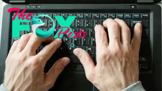 Two hands type on a keyboard.