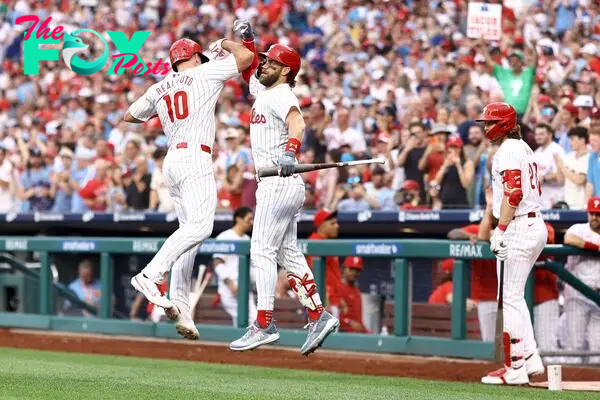Realmuto #10 and Bryce Harper #3 of the Philadelphia Phillies react