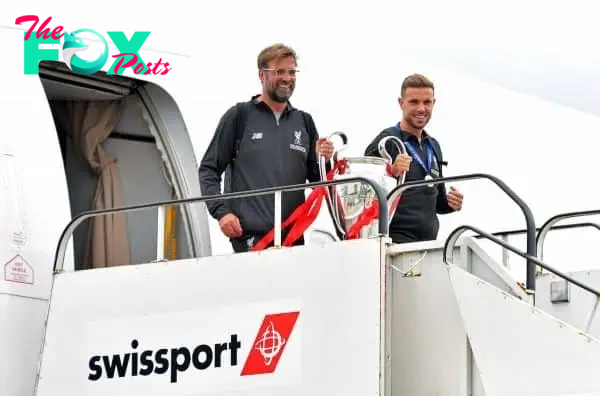 Liverpool manager Jurgen Klopp and Jordan Henderson with the trophy as they arrive back to John Lennon Airport, Liverpool. (PA Images)