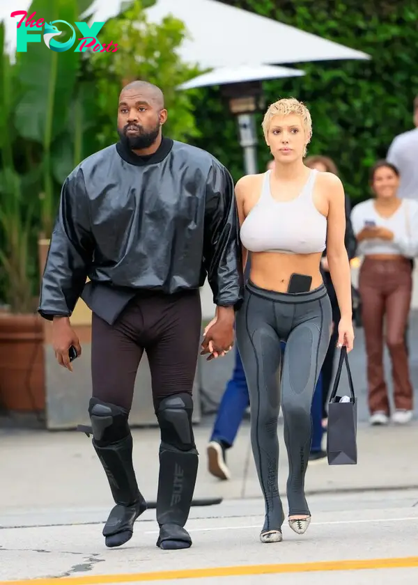 Bianca Censori and Kanye West holding hands. 