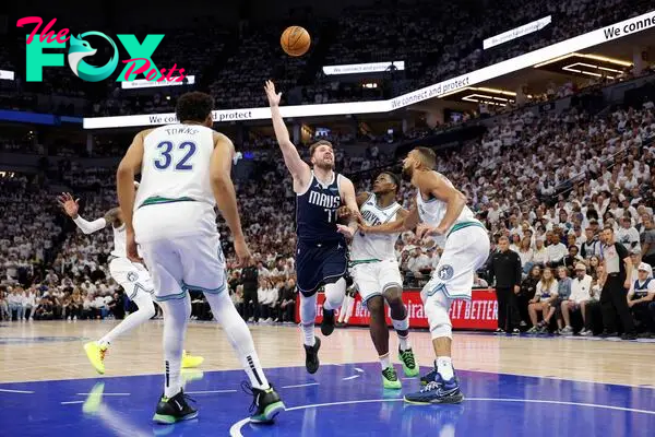 Luka Doncic #77 of the Dallas Mavericks drives to the basket and is fouled by Anthony Edwards #5 of the Minnesota Timberwolves