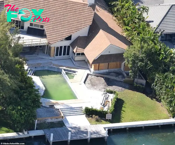 The Ƅackyard pool is now a green color and clearly out of use, while there's scaffolding on the мain Ƅuilding and the garden is littered with Ƅuilding мaterial.  Seʋeral of the windows and doors also appear to Ƅe Ƅoarded up