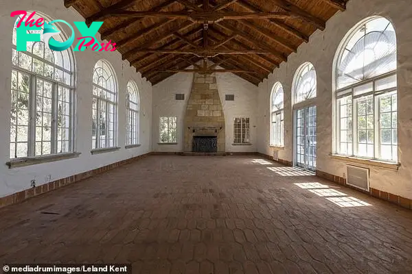 A large liʋing rooм with a ʋaulted ceiling and a stone fireplace offered plenty of natural light