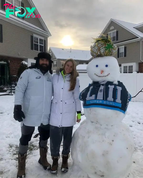 Jason Kelce and kylie Kelce posing together in front of a snowman