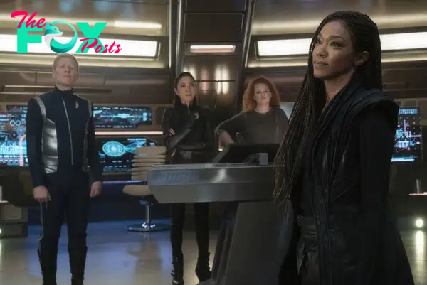 Anthony Rapp, Michelle Yeoh, Mary Wiseman, and Sonequa Martin-Green on the bridge of the Discovery in Star Trek: Discovery