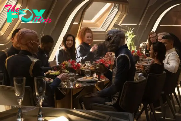 The Discovery crew sitting at a table eating a big meal 