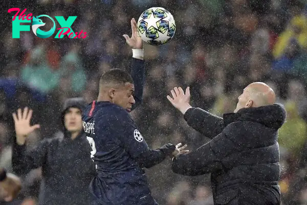 Zinedine Zidane and Kylian Mbappé tussle to get the ball in a Champions League game between Real Madrid and PSG. 