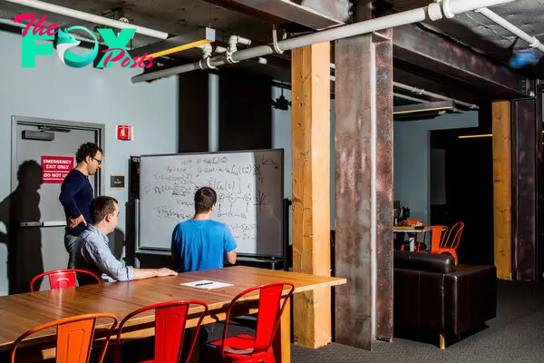 From left: Paul Christiano, Dario Amodei, and Geoffrey Irving write equations on a whiteboard at OpenAI, the artificial intelligence lab founded by Elon Musk, in San Francisco, July 10, 2017.