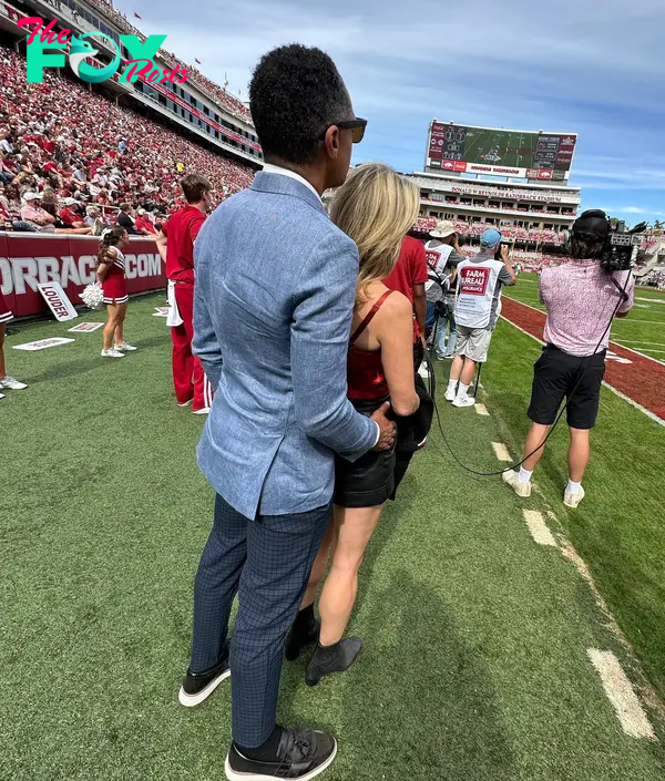 TJ Holmes holding Amy Robach at a University of Arkansas football game