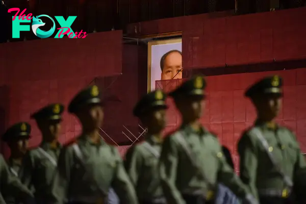 Paramilitary police officers march past a portrait of Mao Zedong on Tiananmen Gate, in Beijing, on May 19, 2019.