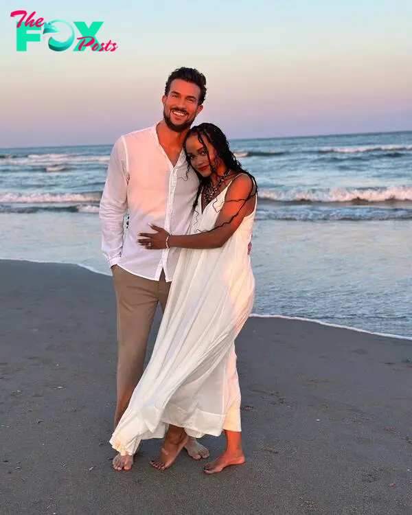 Bryan Abasolo and Rachel Lindsay hugging on a beach.