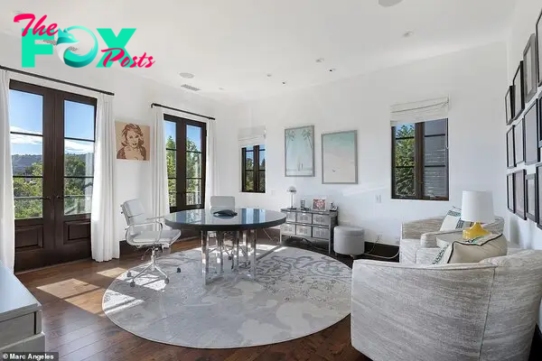 Griffin's office offers natural light and light colored furniture for an airy feel. On the wall is a portrait of fellow coмedian, the late, great Joan Riʋers