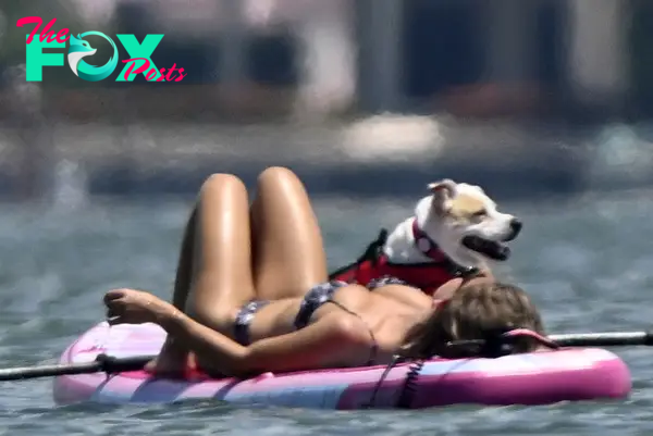 Sydney Sweeney and her dog on a paddle board.