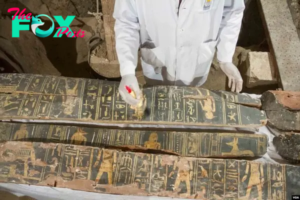 An Egyptian excavation worker restores a coffin found inside the Kampp 150 tomb in the Draa Abul Naga necropolis on Luxor’s West Bank, Egypt, Dec. 9, 2017. (H. Elrasam/VOA)