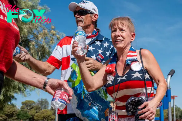 Trish and Rob Vecchio distribute water to supporters of former U.S. President Donald Trump ahead of a campaign rally at Sunset Park on June 9, 2024 in Las Vegas, Nev.