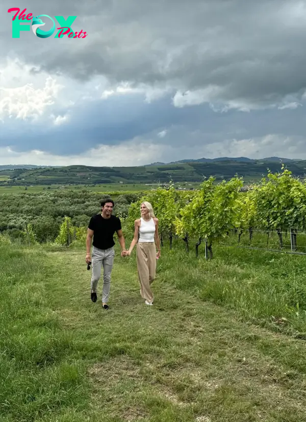 Andrea Denver and Lexi Sundin holding hands in a vineyard