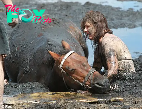 Desperation: Nicole Graham comforts her 18-year-old show horse Astro after he gets stuck in coastal mud as the tide comes in